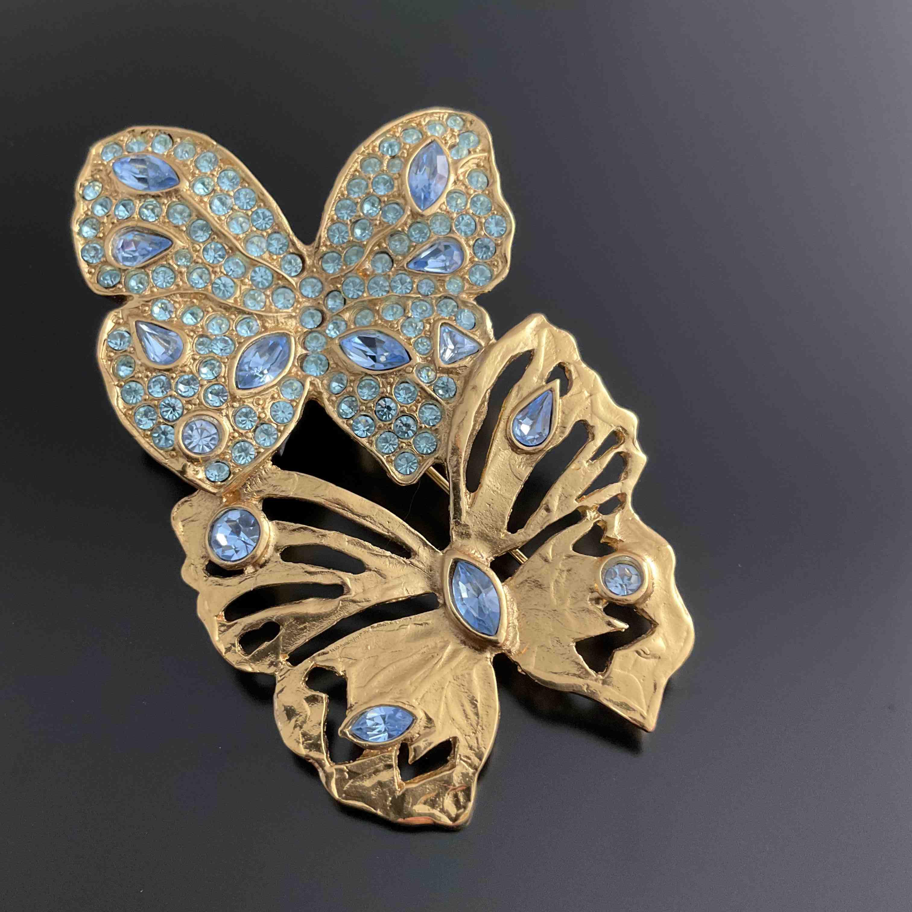 YVES SAINT LAURENT. BROCHE en métal doré figurant deux papillons...