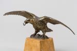 PORTE-MONTRE en bronze doré figurant un aigle au vol éployé....