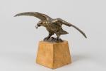 PORTE-MONTRE en bronze doré figurant un aigle au vol éployé....